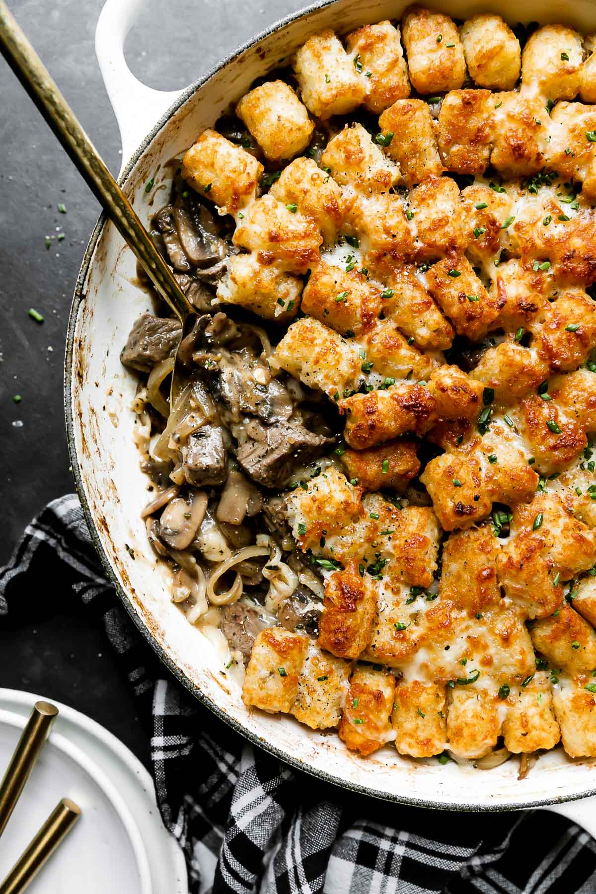 Tater Tot Casserole — Crispy, Cheesy Ground Beef Comfort Food the Whole Family Will Love 28 Close-up of a serving of tater tot casserole being lifted from the baking dish with a spatula, showing the crispy golden tots on top and the cheesy beef filling beneath, with melted cheddar stretching beautifully